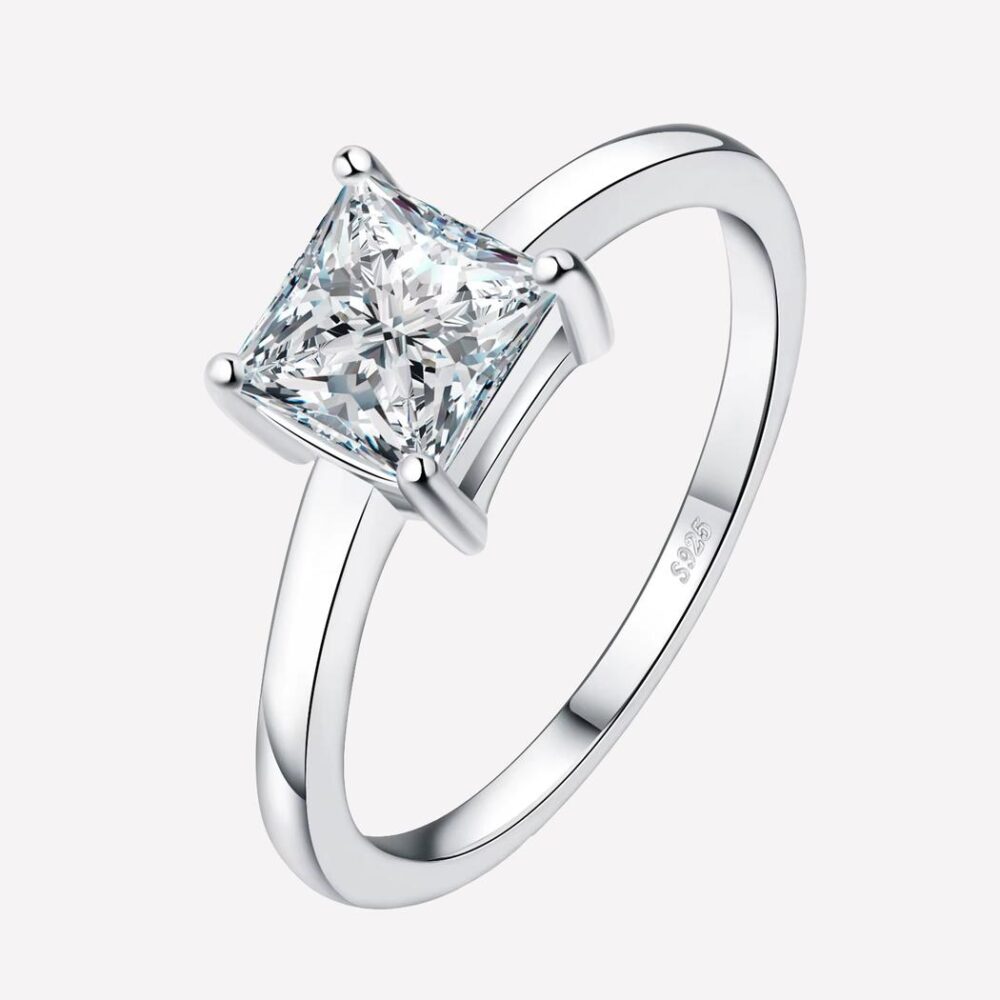 Anneau bague fin avec pierre sur fond blanc.