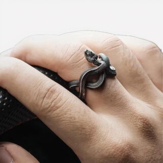 Main homme volant bague serpent noire au majeur