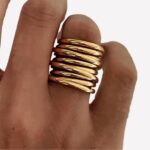 Bague multirangs dorée sur main de femme fine