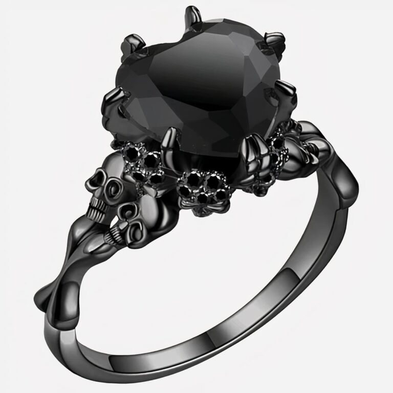 Bague solitaire noire avec cœur orné de tête-de-morts.