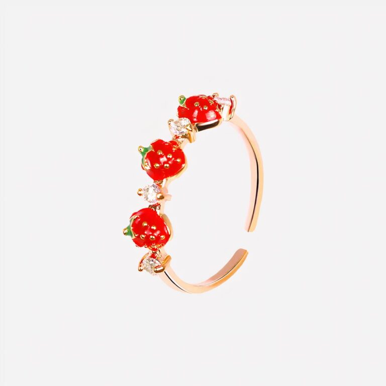 Bague pour petite fille avec des fraises Bague dorée avec des fraises sur fond blanc.