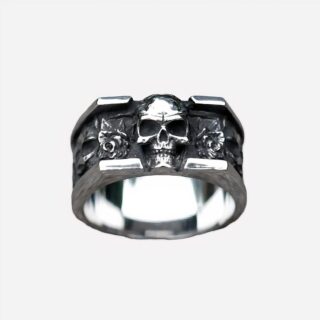 Photo d'une bague pour homme tête de mort en relief en acier argenté sur un fond gris