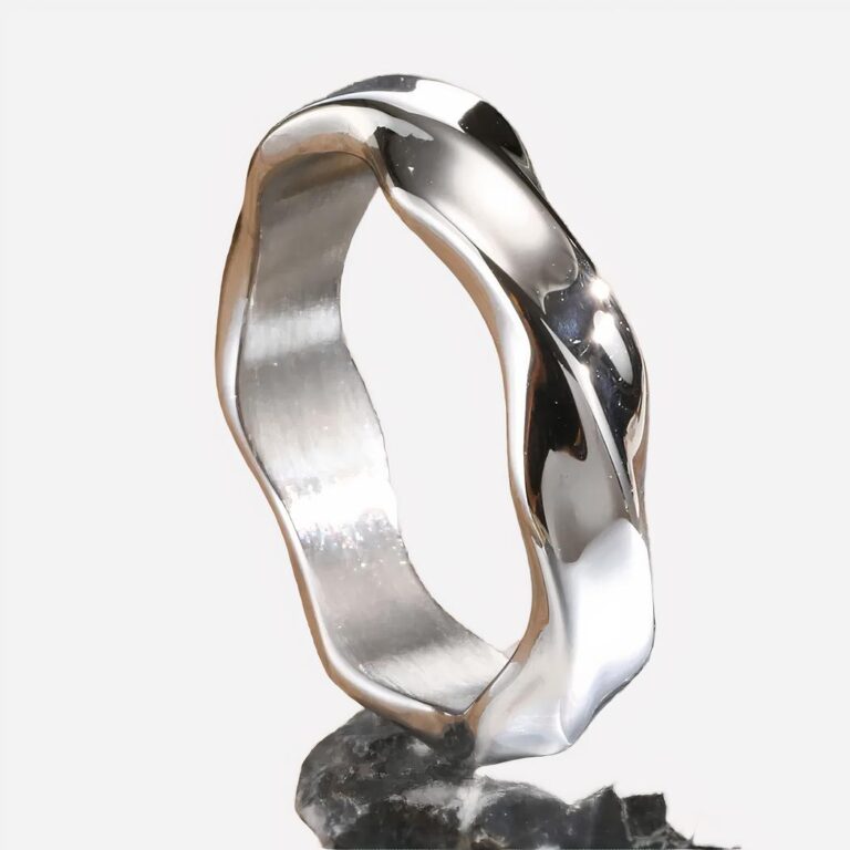 Bague homme moderne torsade Photo d'une bague homme moderne argentée brillante torsade sur une pierre au premier plan et un fond marron