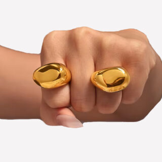 Bague dorées en forme de galet sur une main en forme de poing