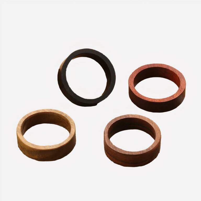 On voit quatre bagues en bois simple anneau de différentes couleurs
