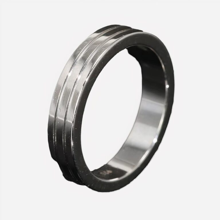 Bague argentée minimaliste sur fond noir.
