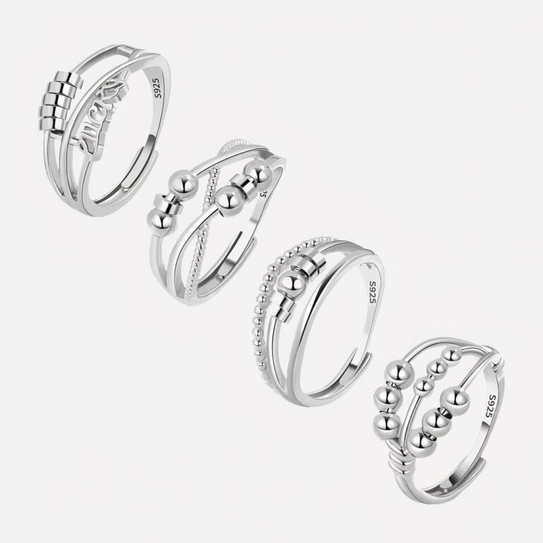 Quatre bagues anti-stress argentées sur fond blanc.