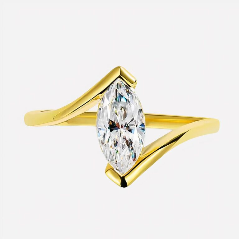 Photo d'une bague moderne dorée ornée d'une grande moissanite taillée en forme marquise sur fond bleu clair