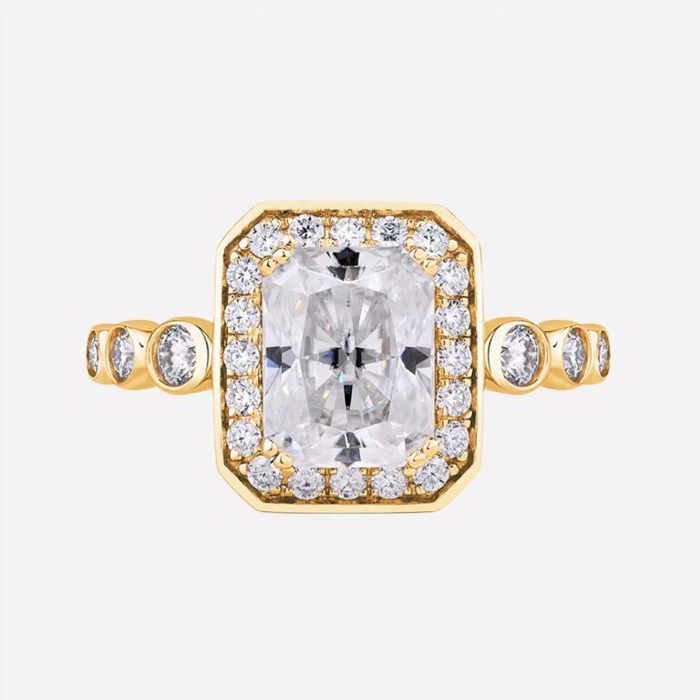 Bague carrée dorée sur fond blanc.