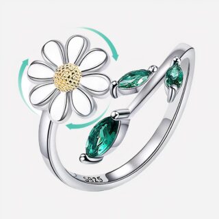 Bague argentée avec une fleur sur fond blanc.