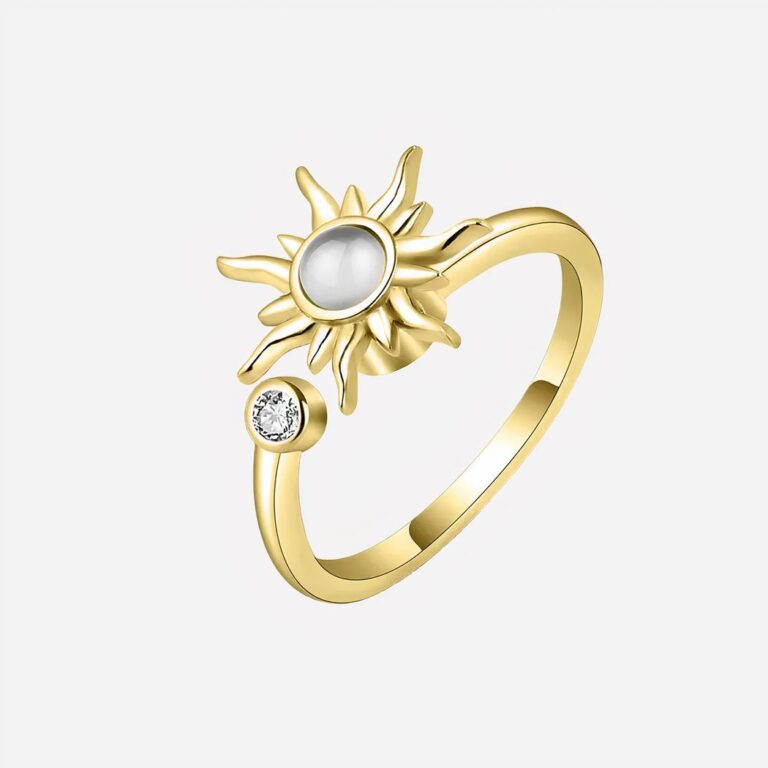 Bague anti stress soleil rotatif pour femme Bague dorée avec soleil sur fond gris.
