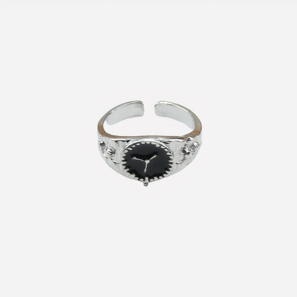 Photo d'une bague ouverte argentée de femme pour l'index en forme de montre sur un fond blanc et ligne beige en haut