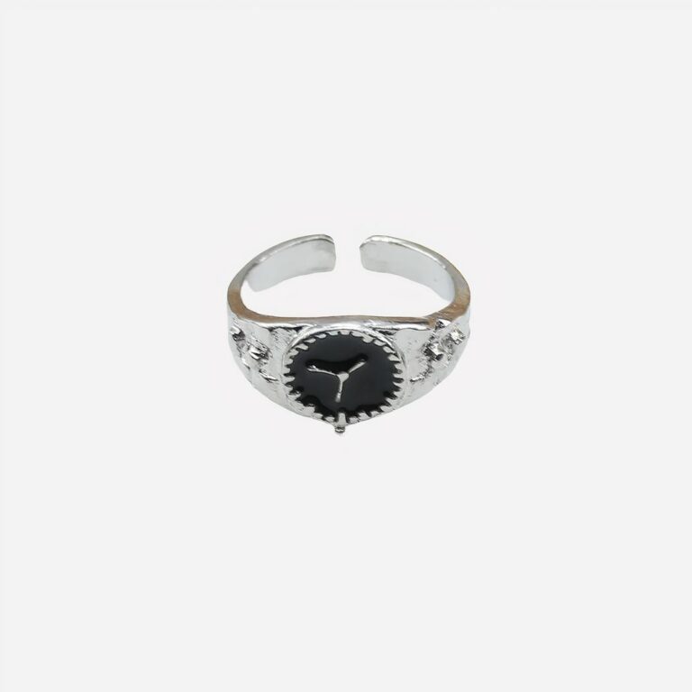 Photo d'une bague ouverte argentée de femme pour l'index en forme de montre sur un fond blanc et ligne beige en haut