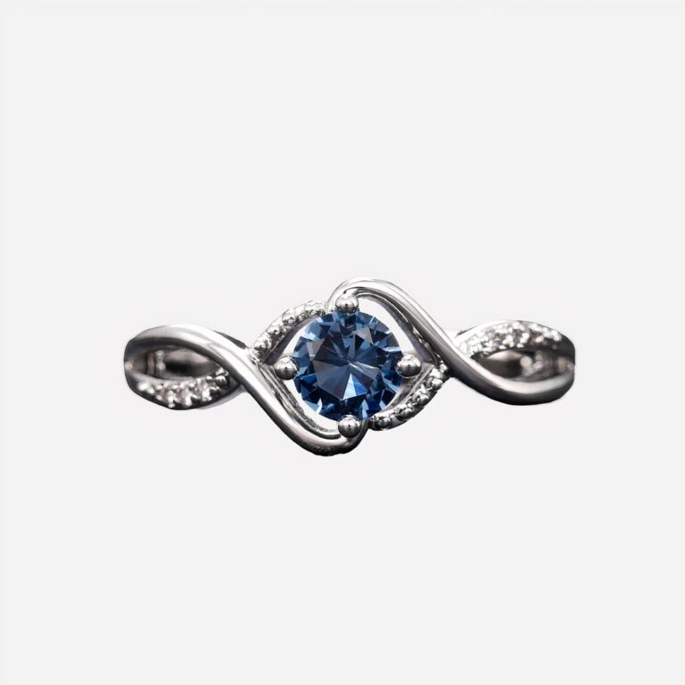 Bague argentée avec pierre bleue sur fond gris.