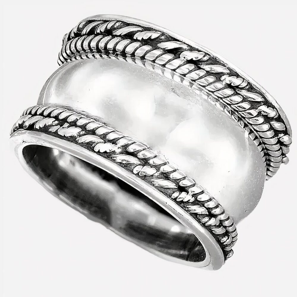 Bague argentée large sur fond blanc.