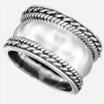 Bague argentée large sur fond blanc.