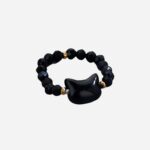 Bague en perles et obsidienne naturelles sur fond gris très clair.